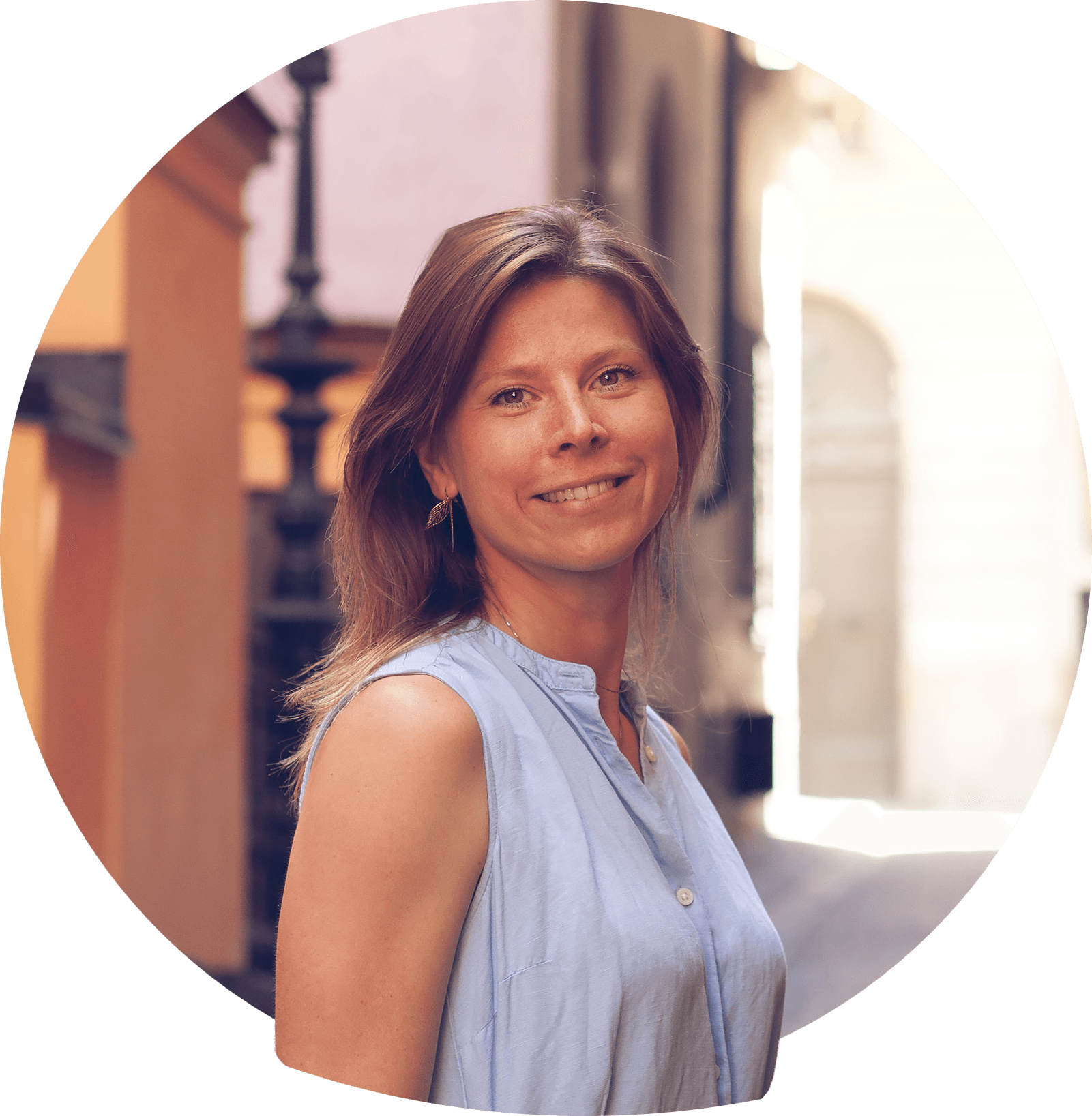 Frida F leende med blont axellångt hår i svart jumper. Foto.