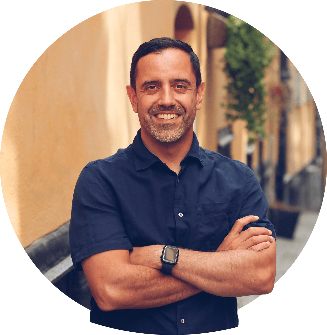 Marcos med stort leende och kort svart hår i ljus pikétröja. Foto.