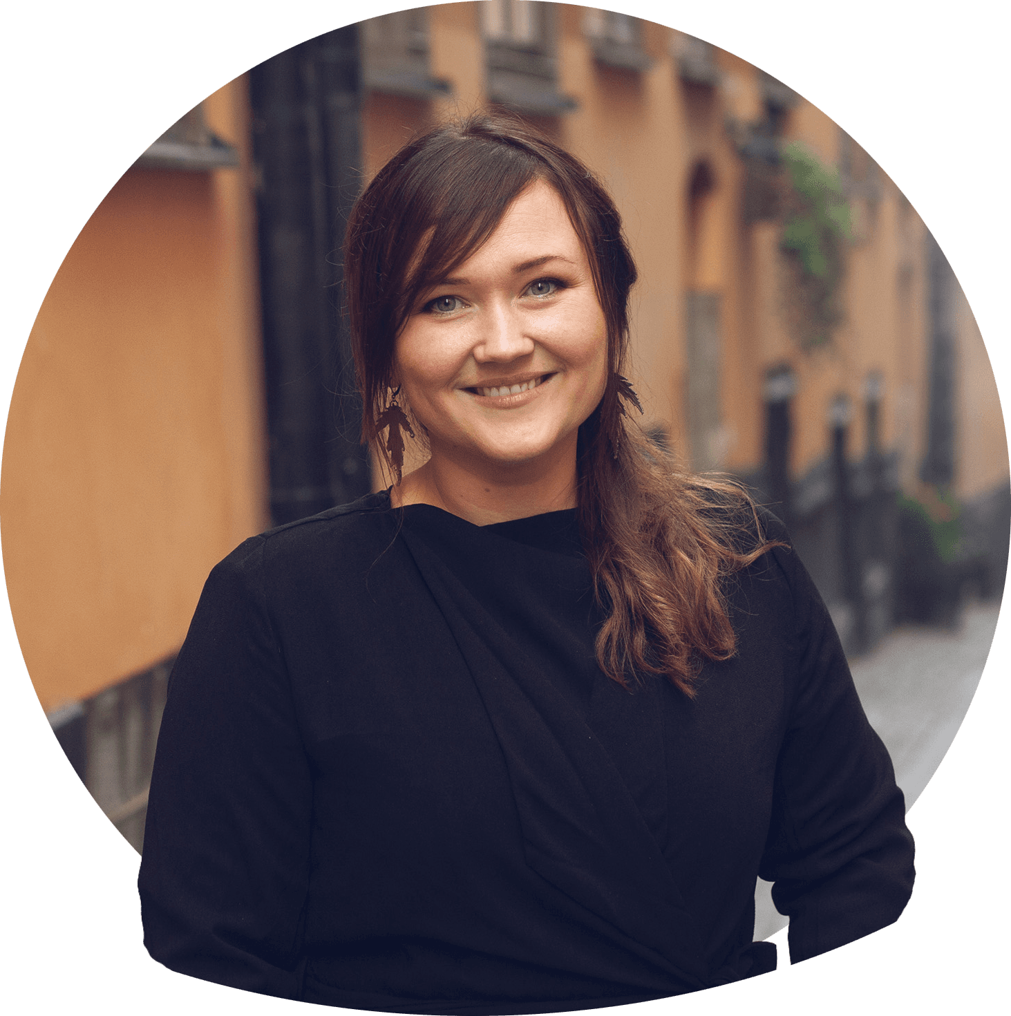 Moa leende med axellångt svart hår, svart jumper ovanpå vit blus med krage. Foto.