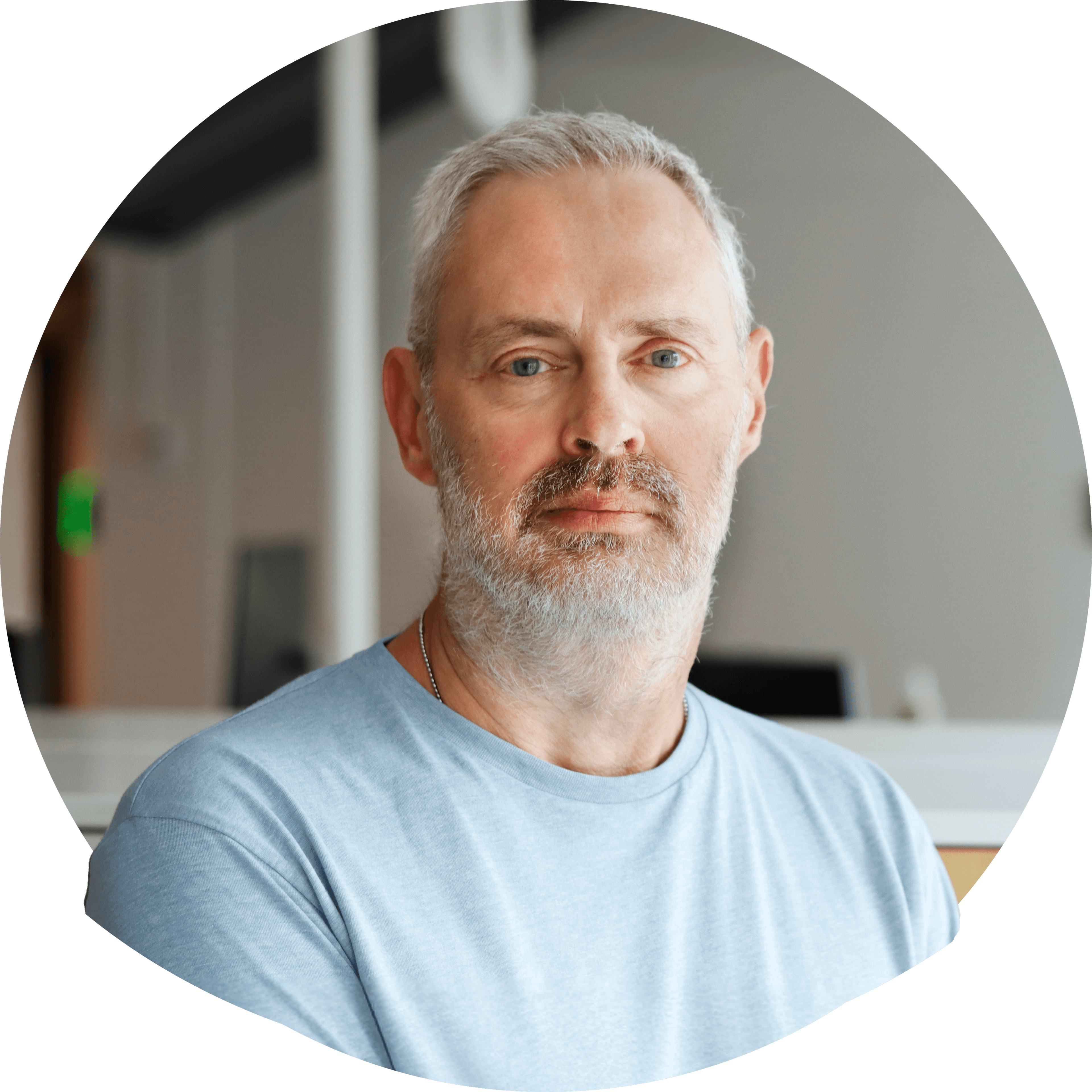 Tommy O i kort silverfärgat hår och kort skägg i ljus t-shirt. Foto.