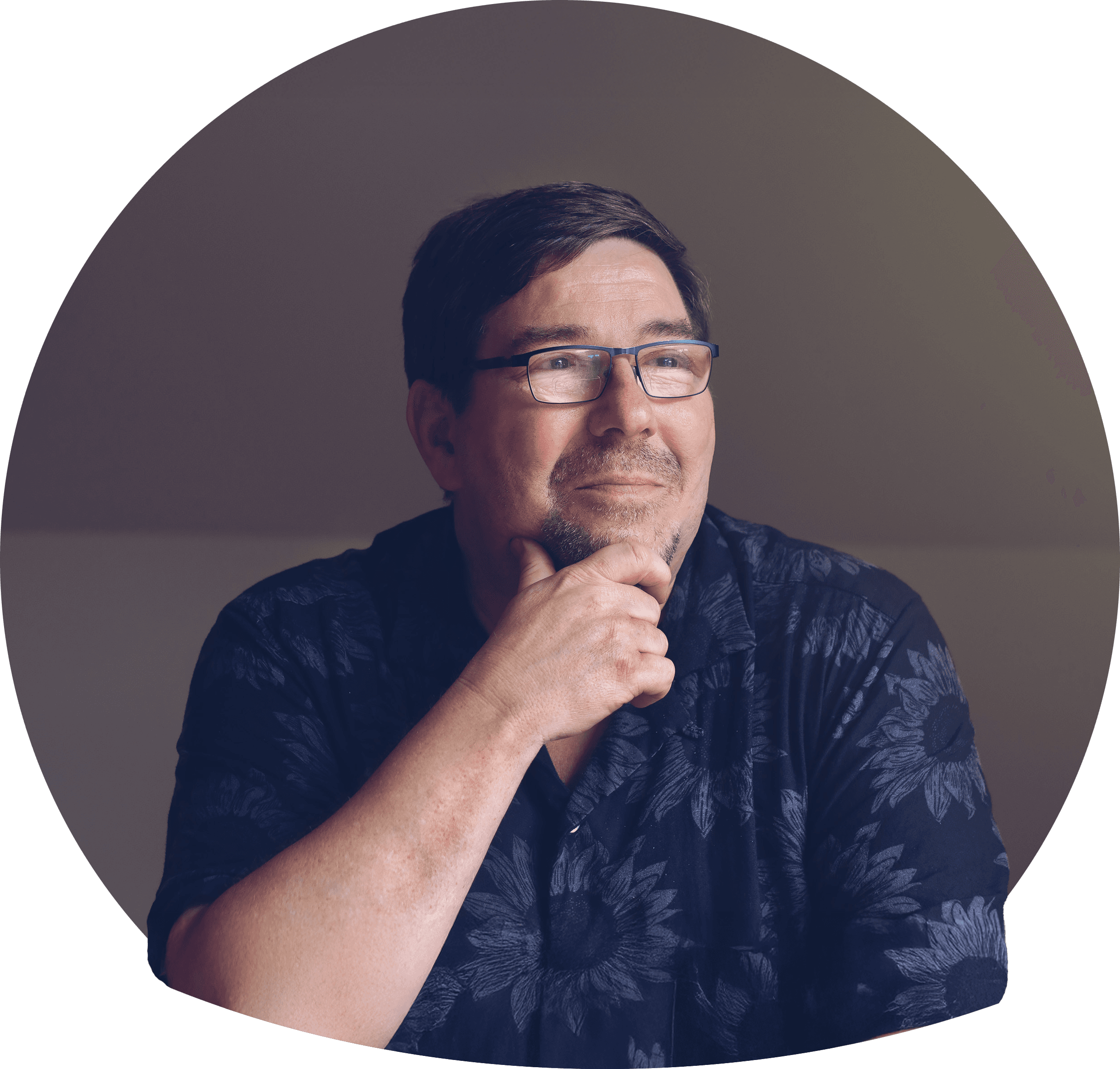 Raouf i ljus storblommig skjorta, mörkt brunt hår och kort skägg. Bär glasögon. Foto.