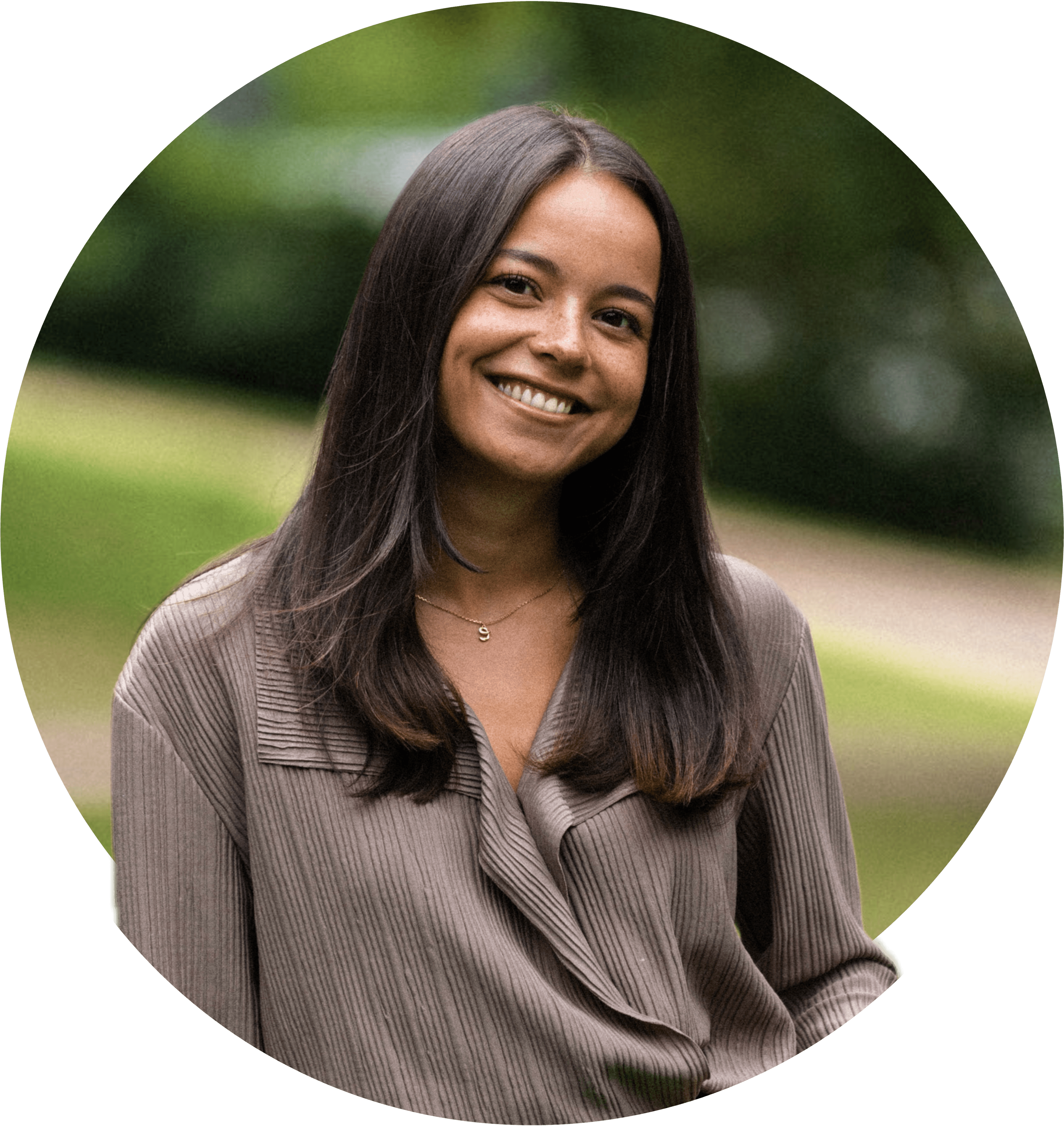 Elsa ler stort, iförd en ljusbrun blus, med mellanlångt brunt hår. Foton.